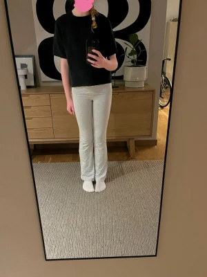 Grå mjukisbyxor från Gina Tricot - Superbekväma grå mjukisbyxor från Gina Tricot med låg midja och utsvängda ben. Storlek är 158/164. Passform- sitter bra och bekvämt på benen och är utsvängda längst ner.