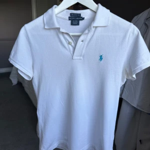 Vit piké från Ralph Lauren - Säljer nu min Ralphlauren piké med blå logga || extremt snygg på sommaren och passar till allt || skulle säga att den passar dig som är 165-170 ish|| var snäll och lämna ett meddelande om du är intresserad || svarar snabbt😊🙌
