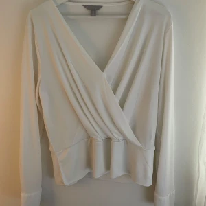 Vit omlottopp med v-ringning H&M - Snygg vit omlottopp.