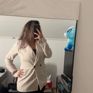 Kavaj  beige och lite svart knappar - Jag säljer en kavaj som är beige med två knappar som är svarta