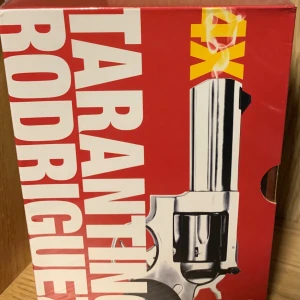 Tarantino Rodriguez DVD-Box - En box med fyra kultfilmer: Pulp Fiction, Sin City, Planet Terror och Death Proof. Perfekt för dig som gillar action, coola dialoger och ikoniska filmskapare. En samling som sticker ut i filmhyllan och bjuder på både spänning och svart humor.