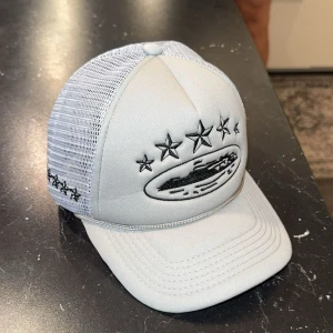 Grå truckerkeps från Corteiz - Säljer en grå truckerkeps från Corteiz. Kepsen har mesh på sidorna och bak, samt justerbar snapback. Broderade detaljer även på sidan och bak. Den är sprillans ny, one size