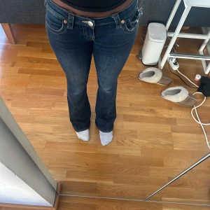 Mörkblå True Religion bootcut jeans -  mörkblå jeans från True Religion med bootcut passform och låg midja. 