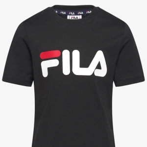 Svart FILA t-shirt med logga - Svart t-shirt från FILA med stor vit och röd logga framtill. Klassisk rund halsringning och korta ärmar. Tillverkad i mjuk bomull för en skön känsla och enkel stil. 