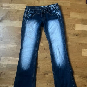  Crazy Age - Lågmidjade crazy age jeans med vita detaljer i fram och bak, storlek 38 / S.                                                  Lite slitna nedtill.                                   Hör av dig vid frågor 💕