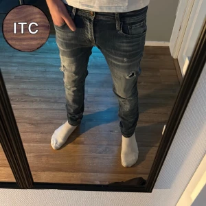 Jack & Jones Jeans - Säljer ett par blå jeans från Jack & Jones med slitna detaljer och snygg tvätt. Storleken är 29/30 och sitter som slim fit.