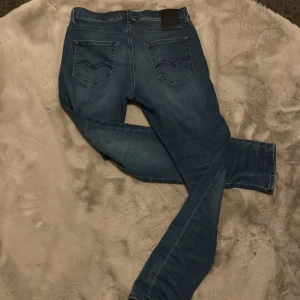 Blå Replay jeans, midja 30 längd 32 - Säljer ett par fetta blå Replay jeans klassisk femficksdesign, Jeansen har raka ben och normal passform, med Replay-logga på bakfickan och dragkedja i gylfen. Perfekta för dig som gillar stilrena och bekväma jeans.