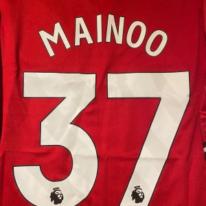 Manchester United Mainoo #37 tröja M - Manchester Uniteds  matchtröja med Mainoo och nummer 37 på ryggen. Adidas-logga, klubbmärke och Snapdragon sponsor på bröstet. Röd färg, V-ringad krage och tillverkad i lätt funktionsmaterial (AEROREADY). Slim fit-modell.