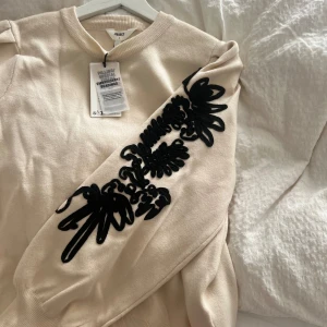 Tröja med detaljerad arm  - Krämförgad tröja med puffärmar. Ny med prislapp, passar även S/M. 