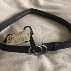 Skärp - Svart skärp från H&M, oanvänd med prislapp kvar! Sju hål. Nypris 80 kr.