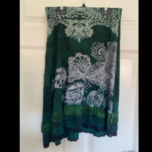 Kjol från Desigual - Grön mönstrad kjol från Desigual. Elastisk midja. Köpt secondhand. I storlek M men går att ha även som xs, s och l skulle jag säga.