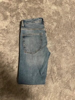 Blåa slim jeans  - Säljer ett par blåa slim jeans med raka ben och klassisk femficksdesign. Jeansen har normal passform och är tillverkade i slitstarkt denimtyg med snygg tvättad look. Perfekta till en avslappnad stil och funkar året runt.