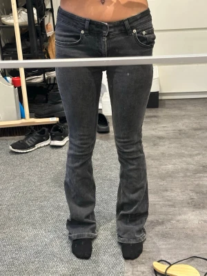 Lågmidjade jeans - Säljer ett par svarta jeans med bootcut passform. låg midja och är tillverkade i mjukt jeansmaterial. Snygg tvättad svart färg som ger en cool vibe. Perfekta till sneakers eller boots.