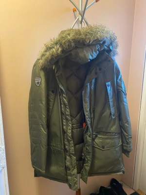 Dunjacka Dressmann  - Jackan har flera fickor, dragkedja och knappar framtill samt patch på ärmen. Avtagbar ljuva. 50% fjäder 50% dun. Använd bara ett fåtal gånger.