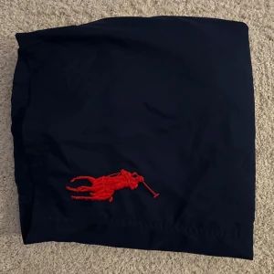 Marinblå badbyxor från Polo Ralph Lauren - Snygga marinblå badbyxor från Ralph Lauren med en stor röd broderad logotyp! 