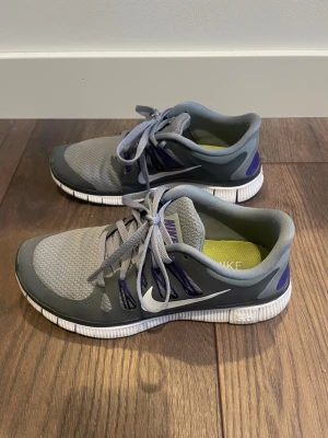 Grå & lila Nike free träningsskor/löparskor storlek 38 - Grå & lila Nike free träningsskor/löparskor storlek 38. Endast använda inomhus på gymmet.