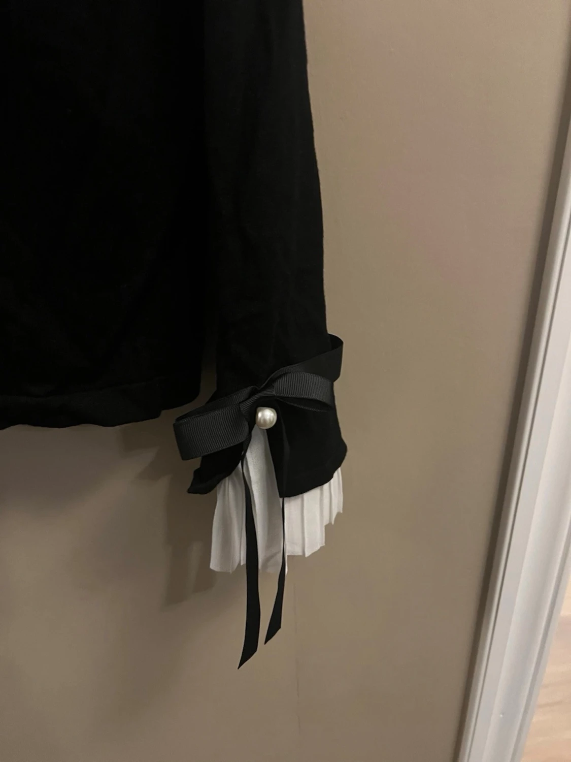 Svart kofta med rosetter och pärldetalj - 1