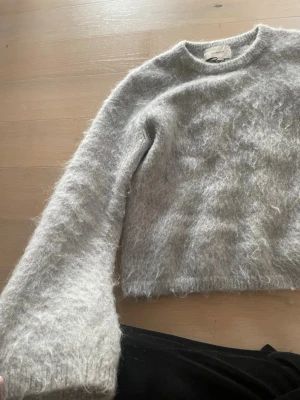 Ljusgrå fluffig stickad tröja H&M - Supermjuk och fluffig ljusgrå stickad tröja från H&M Edition. Tröjan är i superbra skick, skriv vid frågor osv! färgen är lite grå blå, där emellan!