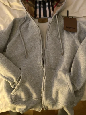 Burberry zip/kofta - Säljer en grå buberry kofta i storlek XS med Burberry tagg och i mycket bra skick. Säljer den för att den är för liten.
