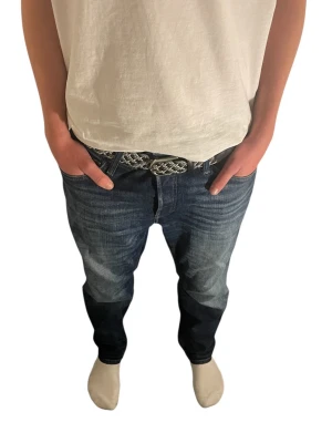 Mörkblå jeans från Jack & Jones 180-190 - Säljer ett par mörkblå jeans från Jack & Jones med klassisk femficksdesign och snygga slitningar. Jeansen har normal passform och raka ben, tillverkade i slitstarkt denimtyg. Perfekta till vardags för en avslappnad look. Modellen är 177 men dem är lite stora i midjan Hör av er via funderingar!