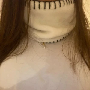 Vit buff med gråa stygn - Handsydd buff med gråa stygn i en vit färg!