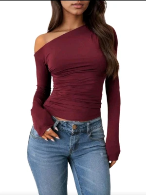 Vinröd oneshoulder topp - Säljer en vinröd oneshoulder topp med lång ärm och tight passform. Toppen har snygga rynkade detaljer i midjan. Passar M och S☺️💕