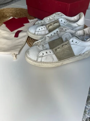 Valentino Garavani vita sneakers - Säljer mina valentino sneakers med guld detaljer. De är välanvända men är fortfarande riktigt snygga. Skosnören ingår, och även ett oöppnat. Skulle rekommendera att köpa egna sulor då jag tycker dessa är ganska hårda så jag har haft egna sulor i. Kartong och äkthetsbevis ingår. Nypris runt 6500kr💖 