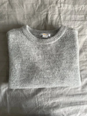 Ljusgrå stickad tröja Gina Tricot - Mysig ljusgrå stickad tröja från Gina Tricot i storlek 146/152. Tröjan har korta ärmar, rund halsringning och är gjord i ett mjukt material som passar perfekt till kyligare dagar. Enkel och stilren design som är lätt att matcha.