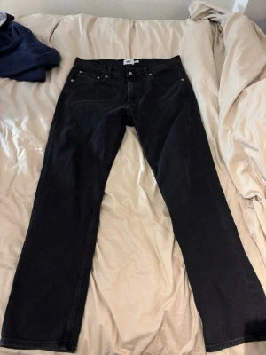 Svarta raka jeansbyxor - Säljer ett par svarta jeansbyxor med klassisk och raka ben. Jeansen har normal passform och är tillverkade i ett slitstarkt bomullsmaterial. Perfekta till vardags och enkla att matcha med olika stilar.