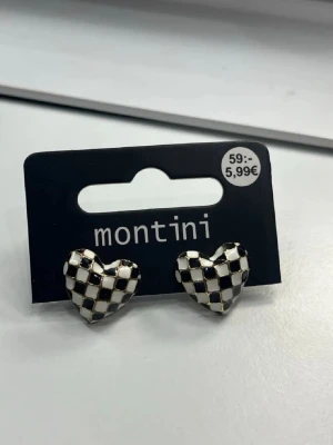 Hjärtformade rutiga örhängen Montini - Säljer ett par hjärtformade örhängen från Montini med svartvitt rutigt mönster. Perfekta accessoarer för dig som vill sticka ut med en lekfull och trendig stil.