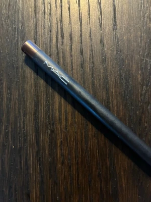 MAC Teddy Eye Kohl eyeliner - Säljer en MAC Teddy Eye Kohl eyeliner i en djup, varm brun nyans med lätt skimrig finish. Pennan är klassiskt svart med brunt lock och tydlig MAC-logga. Perfekt för att skapa mjuka eller intensiva ögonlooks. Innehåller 1,36 g. Knappt använd. Full size. 