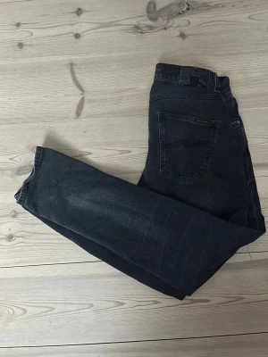 Nudie jeans grim tim - Säljer ett par svarta jeans från Nudie Jeans i modellen grim Tim, vilket är slim/straight passform.