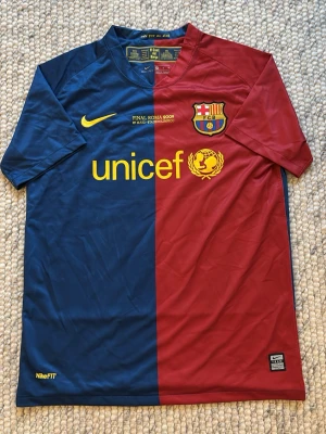 FC Barcelona Nike matchtröja 2009 - Säljer en ikonisk FC Barcelona matchtröja från Nike, Final Roma 2009 edition. Tröjan är i klassiska blå och vinröda färger med gula detaljer, klubbmärke och UNICEF-logga på bröstet. Tillverkad i Dri-FIT polyester för bästa komfort. Tveka inte med att fråga om fler bilder eller annat!