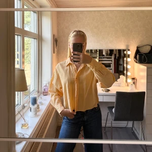 ljusorange medelcroppad skjorta från Gina Tricot - medelcroppad linneskjorta i ljusorange kulör från Gina Tricot. Skjortan har krage, knappar framtill och långa ärmar med manschett. Luftig och lätt, perfekt för varmare dagar. Enkel och stilren design som ger en fräsch vibe. Passar att knäppa och ha för sig, eller med någon snygg topp under, eller varför inte bikini❤️‍🔥