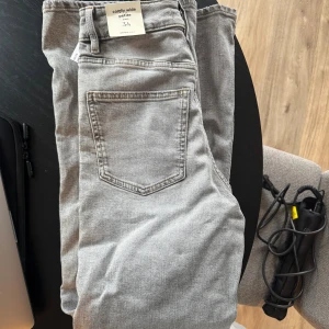 Grå comfy wide jeans petite 34 - Grå jeans i modellen comfy wide petite med klassiska bakfickor och hög midja. De är helt oanvända🩷