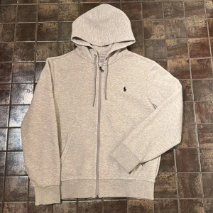 Grå Ralph Lauren zip hoodie - Säljer denna snygga, gråa Polo Ralph Lauren tröjan pga att den var för liten för mig!  Perfekt till hösten!🍁 Skick: 9/10✅ Nypris:2395kr💸 Storlek M, jag upplever storleken som S/M. Hör av dig vid intresse eller minsta fundering! 