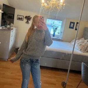 Grå stickad tröja  - Säljer en grå stickad tröja med rund hals och ribbade muddar. 💕Tröjan har en enkel och clean look, perfekt att slänga på sig när det är kallt. Långärmad och i en normal passform som funkar till ALLT!!!🤗✨🫶