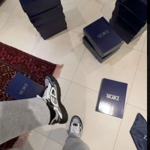 Dior B30 sneakers svart/vit - (PRIS KAN DISKUTERAS!) Säljer ett par Dior B30 sneakers i svart och vitt med stora CD-loggor på sidorna. Skorna har chunky svart sula, mesh och skinnpaneler samt vita snören. Riktigt snygga och trendiga sneakers som sticker ut med sin futuristiska design.