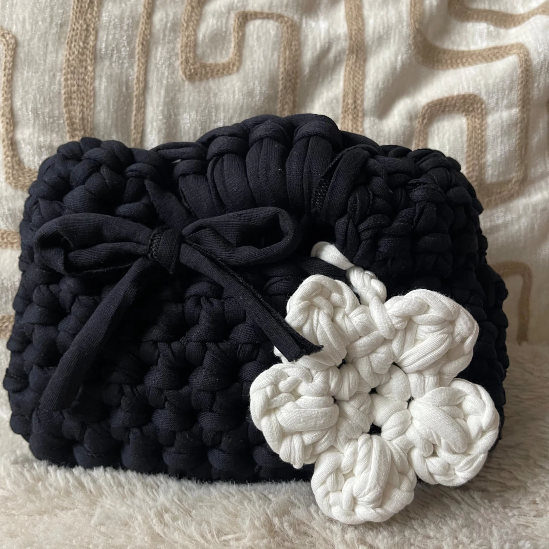 Svart handväska med virkad blomma