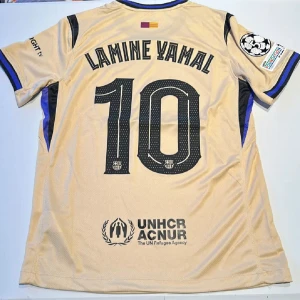 Barcelona Lamine Yamal #10 bortatröja - Snygg beige Barcelona bortatröja med Lamine Yamal och nummer 10 på ryggen. Tröjan har svarta detaljer, klubbmärke, Spotify-logga och Champions League-patch på ärmen. Tillverkad i lätt och ventilerande polyester, perfekt för match eller samling. Replika, endast handtvätt gäller!