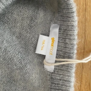 Grå stickad T-shirt - Young Gina  - En grå stickad T-shirt ifrån Young Gina, använd 1-3 gånger (prislapp på bilden men är nu avklippt), storlek 158-164, priset kan diskuteras, skriv vid intresse eller fler bilder🩶