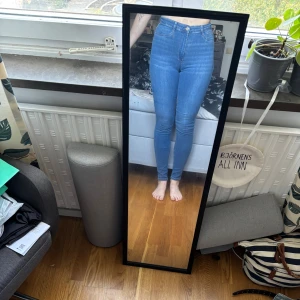 Blå högmidjade skinny jeans - Säljer ett par ljusblå skinny jeans med hög midja. Jeansen har smal passform hela vägen ner och är tillverkade i stretchigt denim för en bekväm känsla. Perfekta för dig som gillar en tight och modern look. Endast använda 2-3 gånger så är som nya. Pris går att diskutera