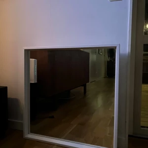 Spegeln med vit ram - På bilderna visas en spegel med vit ram, avsedd för väggmontering. Spegeln är från Ikea och heter Nissedal. Produkten är i gott skick utan synliga defekter. 