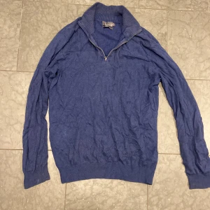 Blå halvzip kashmirtröja D. Signature - Mysig blå stickad tröja från D. Signature i kashmirblandning. Tröjan har halv dragkedja vid kragen och ribbade muddar. Perfekt för dig som gillar en klassisk look med lite extra lyxkänsla.