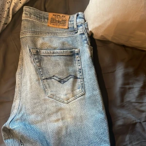 Replay  - Säljer ett par ljusblå jeansbyxor från Replay med klassisk femficksdesign och snygga detaljer på bakfickan. Jeansen har en skön passform och är perfekta för en avslappnad stil. Märkespatch i läder baktill i midjan.