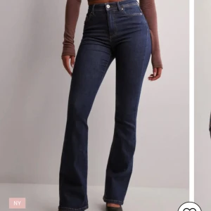 Mörkblå bootcut jeans från Only - Snygga mörkblå jeans från Only med bootcut passform och hög midja. Jeansen har klassisk femficksdesign, gylf med dragkedja och knapp samt en skön stretchig denimkvalitet. Perfekta för en trendig och avslappnad look.