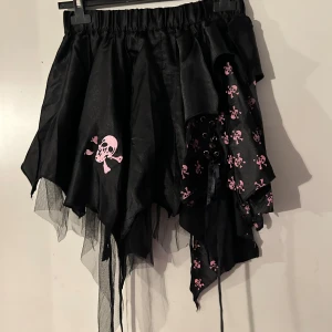 Kjol från Poizen i stl onesize. Märke Poizen - Helt ny kjol från Poizen. Resår i midjan. Storlek onesize. Snörning på sidan fram och  två snörningar bak.Helt ny.