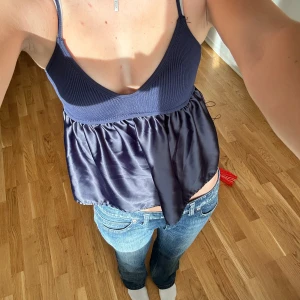 Mörkblå linnetopp - Supersöt mörkblå topp med smala axelband och v-ringning.  Perfekt till jeans eller kjol för en trendig look.