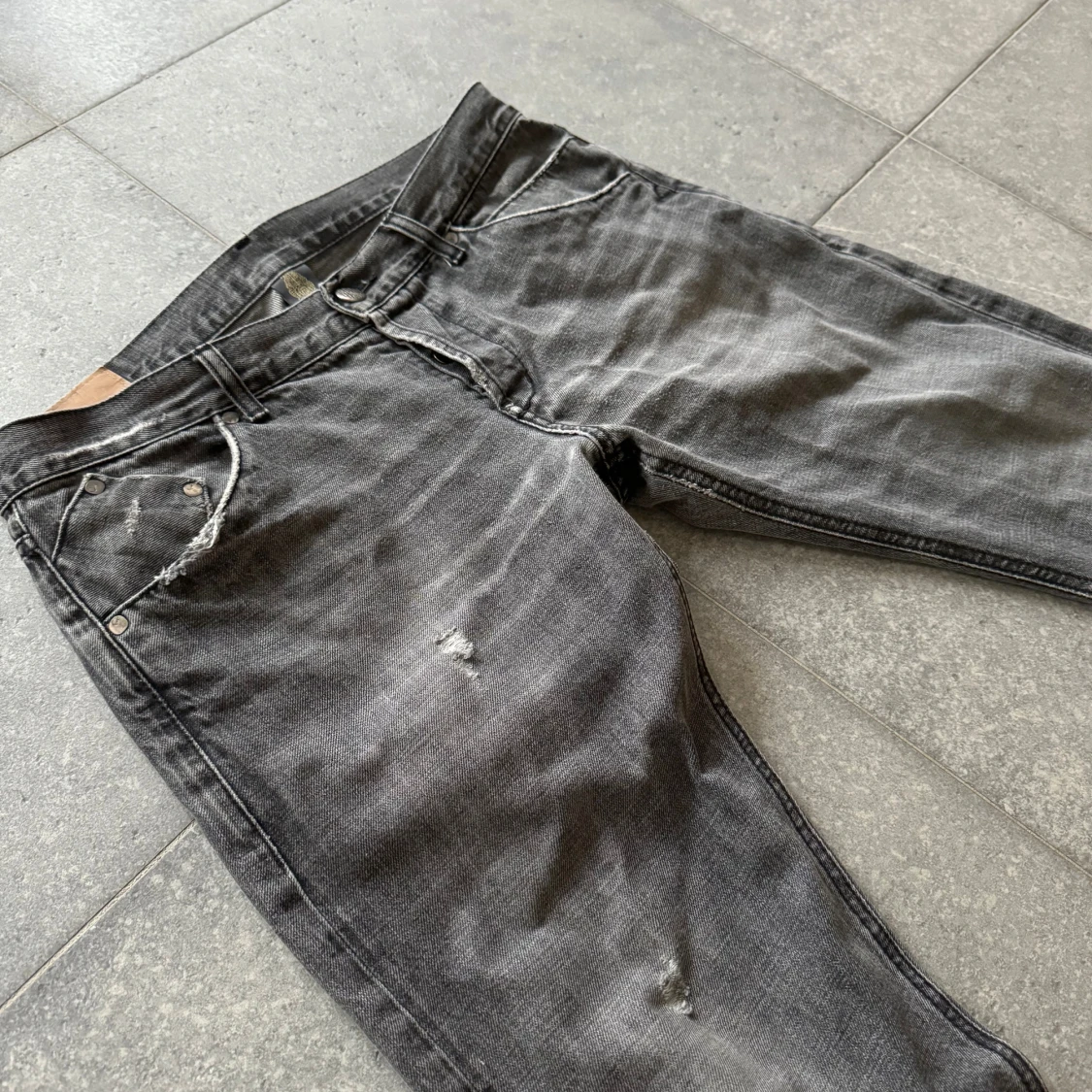 Grå jeans med slitningar