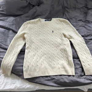 Vit kabelstickad tröja Polo Ralph Lauren - Vit kabelstickad tröja från Polo Ralph Lauren. Säljer den pågrund av att det är för liten! Passar M/L. Är som ny med inga defekter! Pris kan diskuteras vid snabb affär! Nypris ligger på 2699!